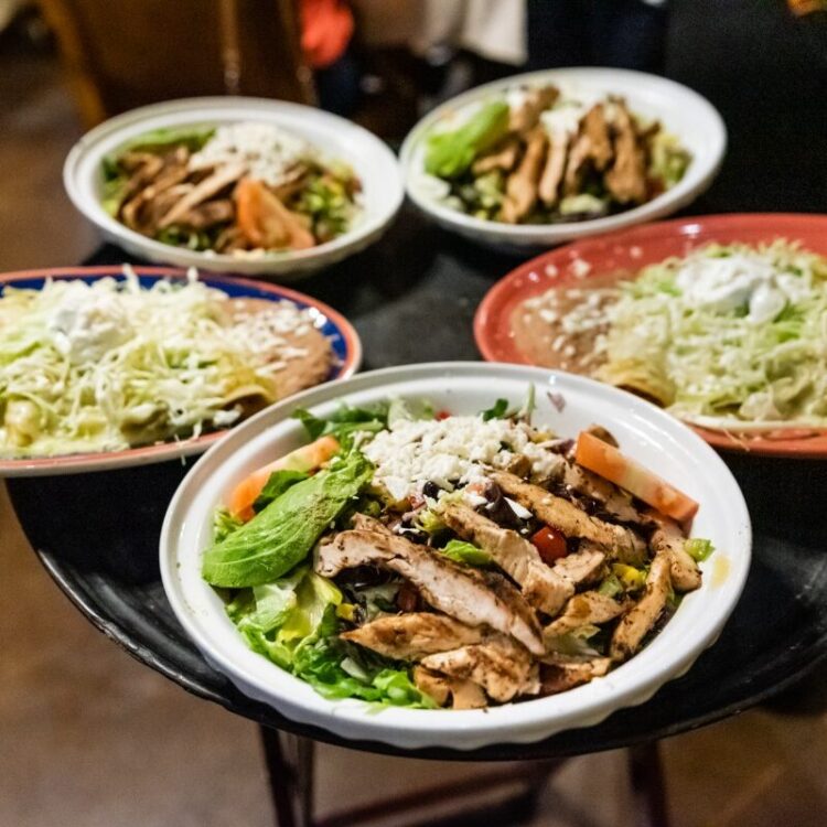 Chicken salads and dinner plates on tray