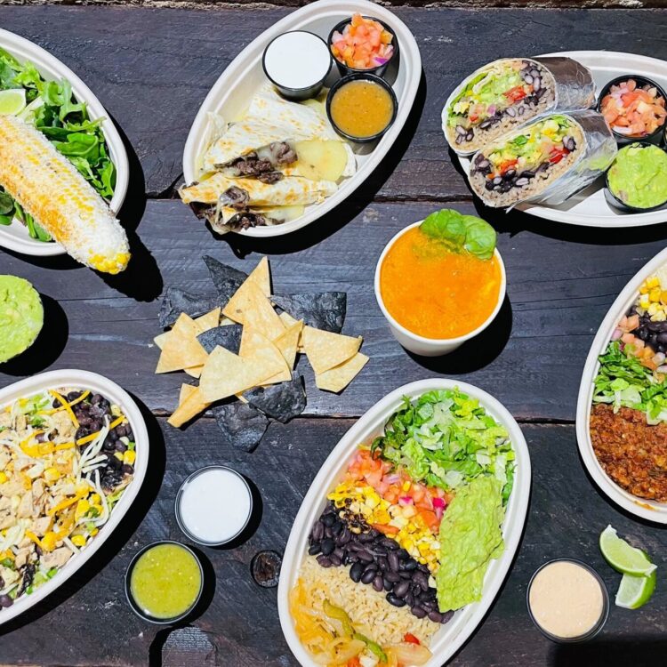 Maiz NYC - Dark table top covered with food plates