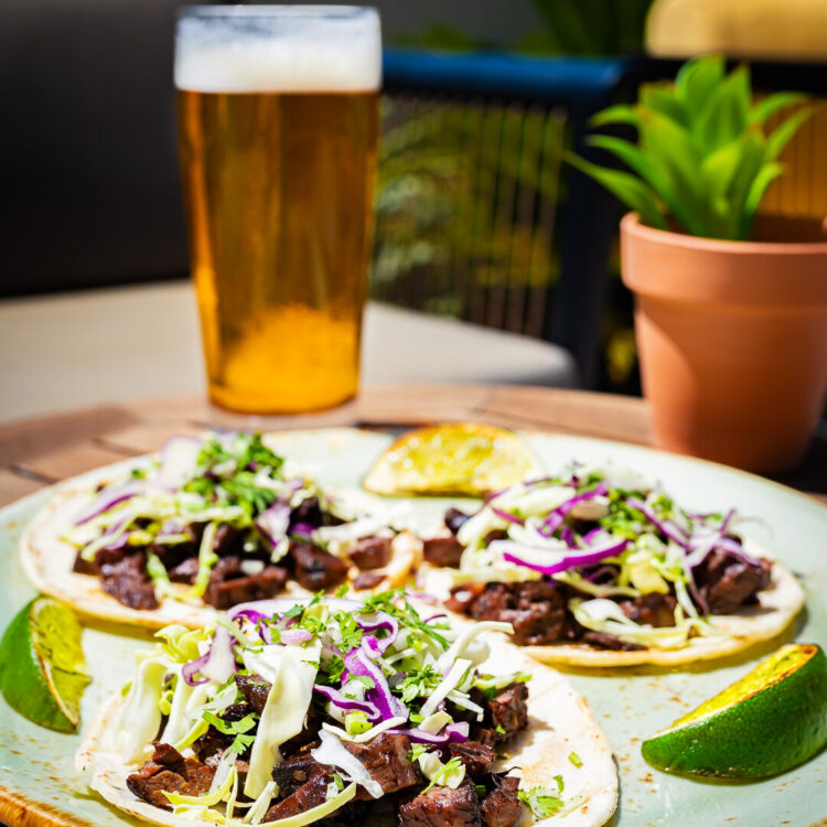 3 carne asada tacos with lime wedge