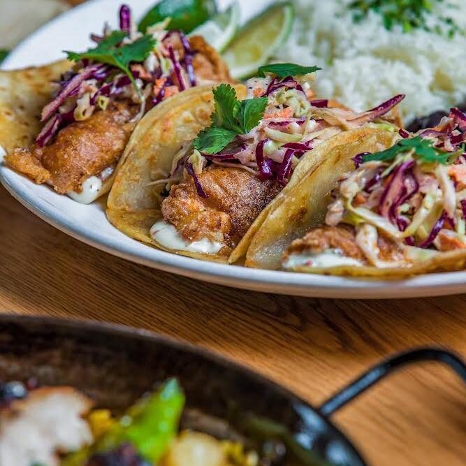 Fish Tacos- Baja style ~ flash fried white fish, lime aioli slaw, pickled onion, rice, and black beans