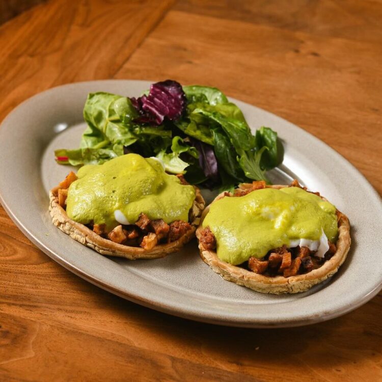 Huevos benedictinos - Thick tortilla, poached eggs, longaniza, potato, poblano sauce, and salad