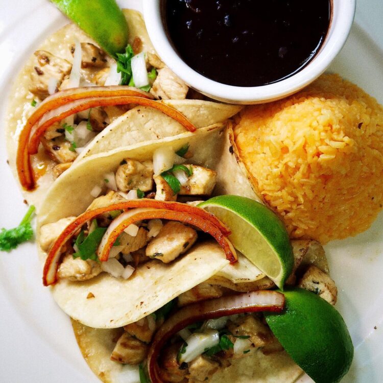 Plate of chicken nachos with side of rice and black beans