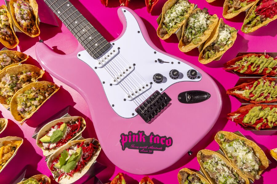 Pink Taco Pink Guitar surrounded by tacos on a pink background