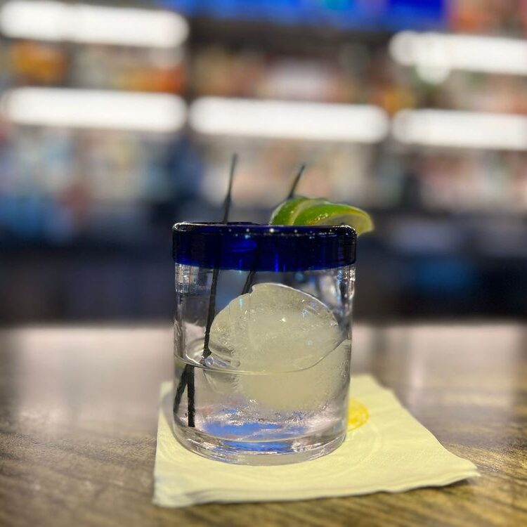 Tequila shot with lime wedge on the rocks