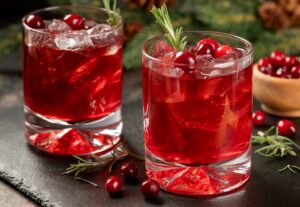 Cranberry,Cocktail,With,Fresh,Cranberries,And,Roseemary,On,Black,Slate