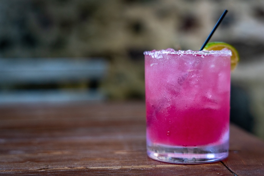 Fancy,Pink,Mixed,Drink,At,Rustic,Bar