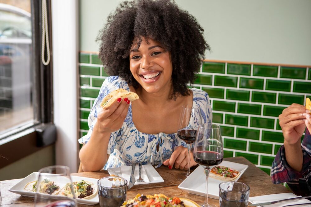 Uk,,London,,Smiling,Woman,Enjoying,Me,ican,Food,At,Restaurant,Table