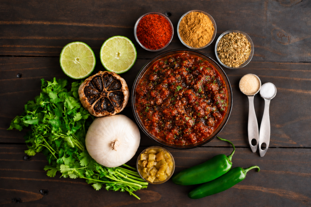 Make smoky black garlic salsa with roasted tomatoes, jalape&ntilde;o, lime, and cilantro. This easy homemade recipe is perfect for tacos, quesadillas, and chips.