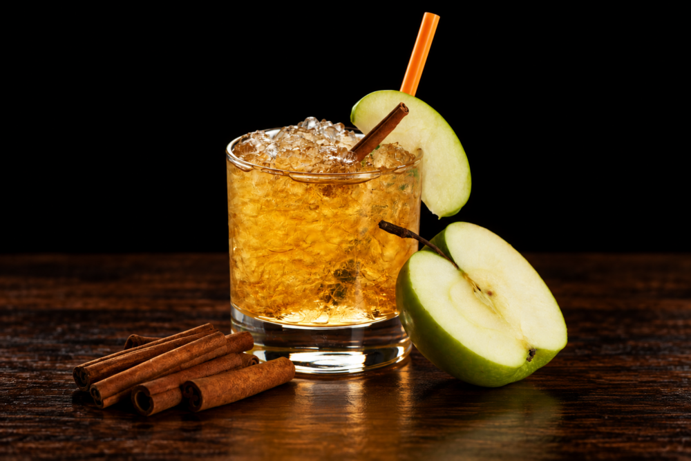 Cocktail with sliced apples and cinnamon sticks