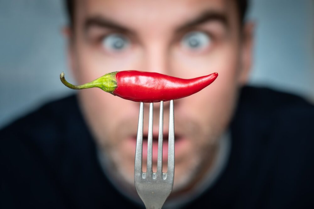 Ridiculous,Expression,Of,Man,With,Hot,Chillies,In,His,Hand.